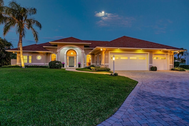 view of front facade with a garage and a lawn