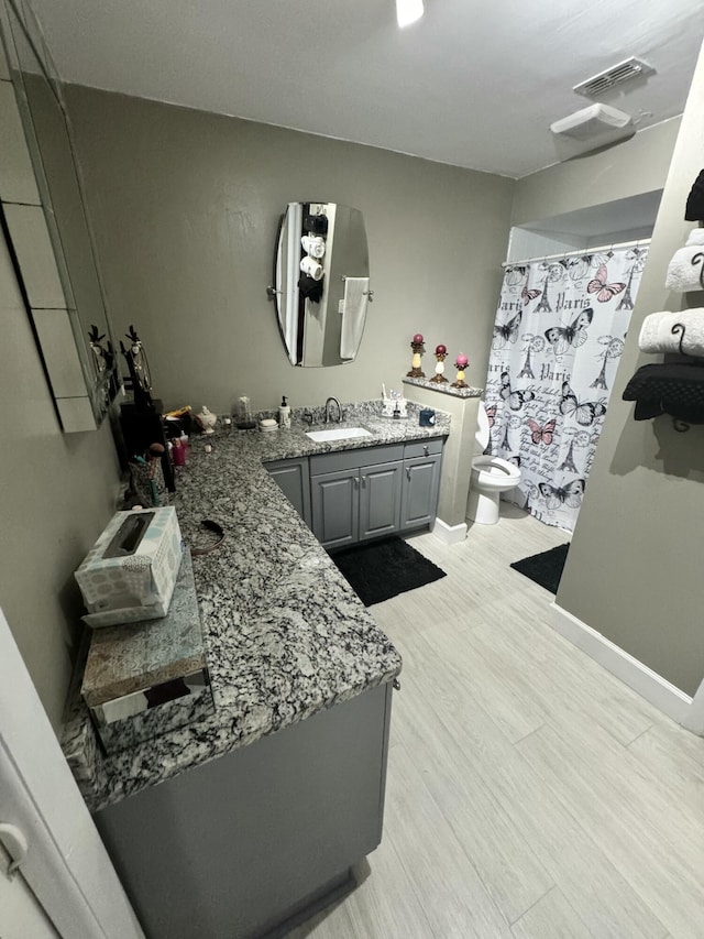 bathroom with walk in shower, vanity, toilet, and hardwood / wood-style floors