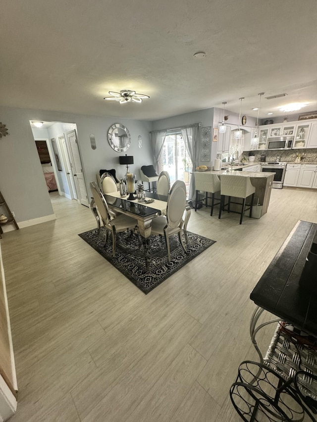 dining area featuring sink and light hardwood / wood-style floors