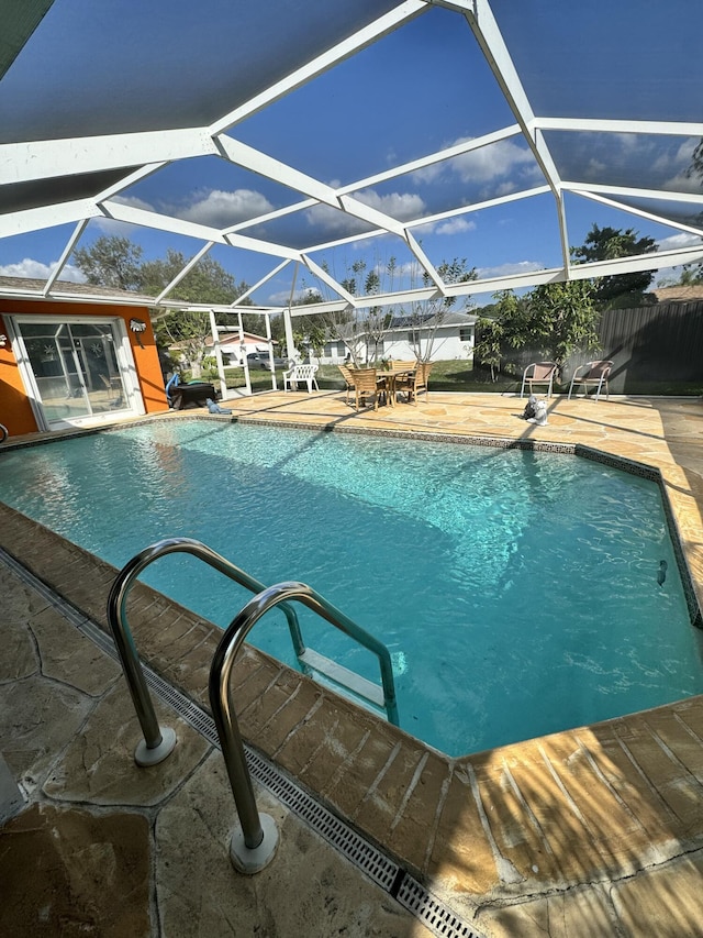 view of swimming pool featuring a patio area and glass enclosure