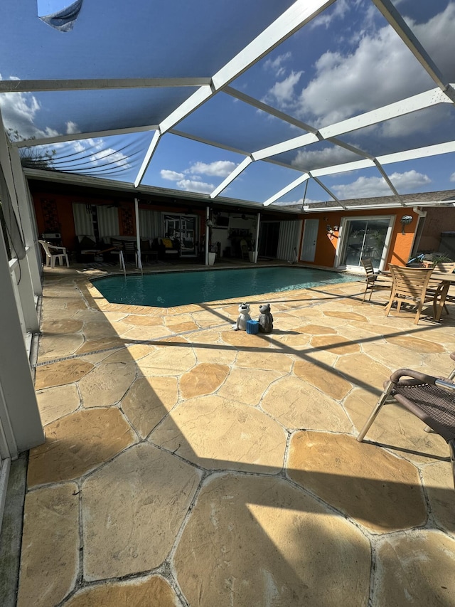 view of swimming pool with a lanai and a patio area