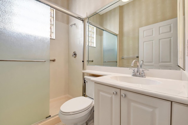 bathroom featuring vanity, an enclosed shower, and toilet