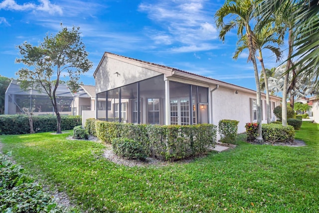 view of side of property featuring a yard and a sunroom