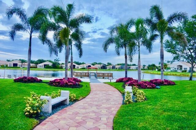 surrounding community featuring a water view and a yard