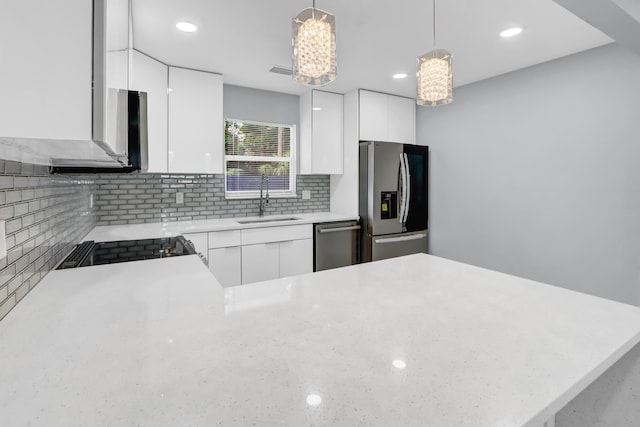 kitchen featuring pendant lighting, kitchen peninsula, white cabinets, and appliances with stainless steel finishes