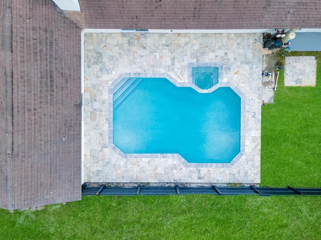 view of swimming pool featuring a yard