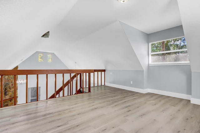 additional living space with vaulted ceiling and light wood-type flooring