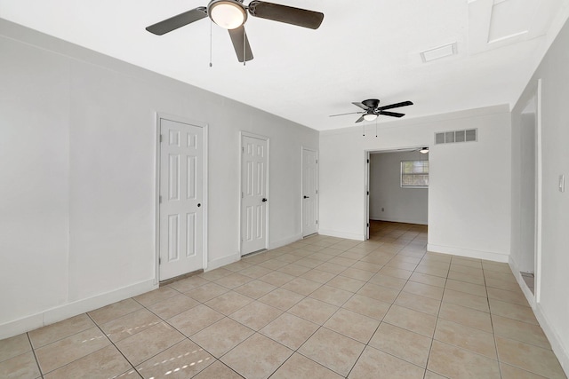 empty room featuring ceiling fan and light tile patterned floors