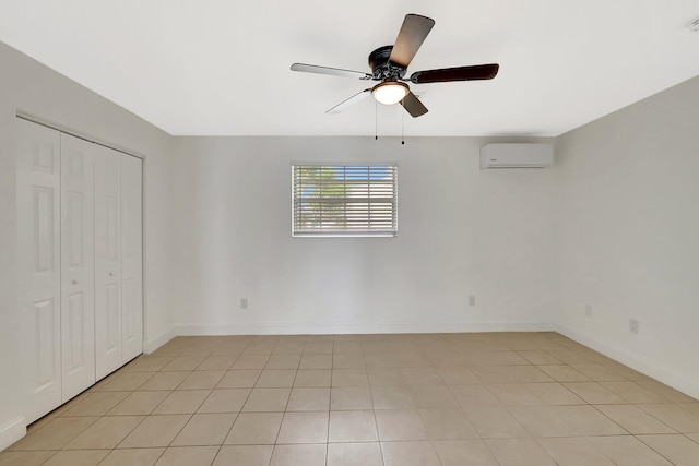 unfurnished bedroom with ceiling fan, light tile patterned floors, a closet, and a wall mounted AC