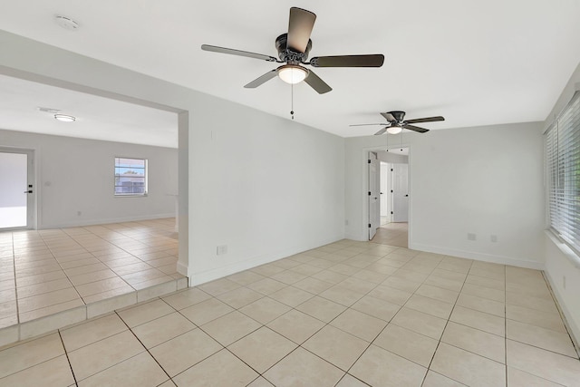 spare room with ceiling fan and light tile patterned floors