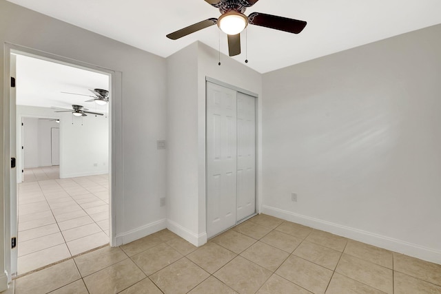 unfurnished bedroom featuring light tile patterned floors, a closet, and ceiling fan