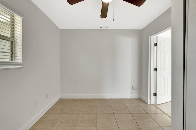 tiled spare room with ceiling fan