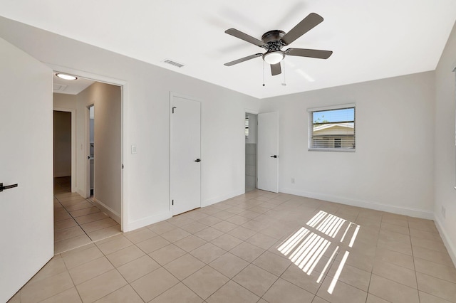 empty room featuring ceiling fan and light tile patterned floors