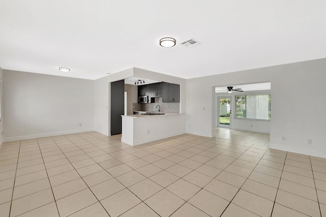 unfurnished living room with ceiling fan and light tile patterned floors