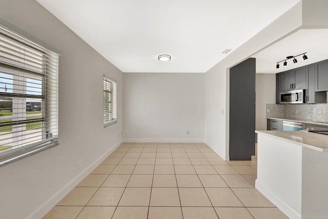 interior space with light tile patterned flooring and rail lighting