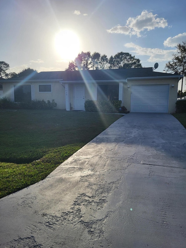 ranch-style house featuring driveway, a lawn, and an attached garage