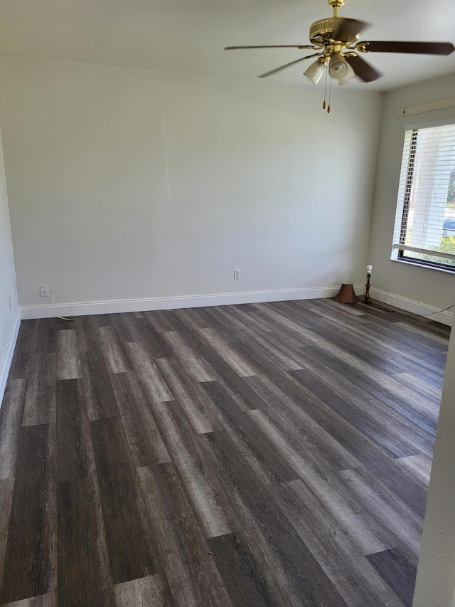 unfurnished room featuring ceiling fan, dark wood finished floors, and baseboards