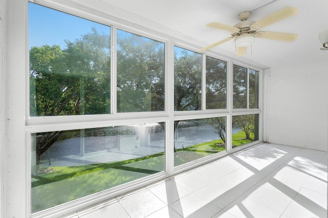 unfurnished sunroom featuring a water view and ceiling fan