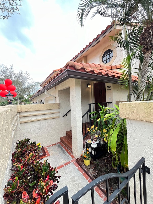7895 La Mirada Dr, Boca Raton, FL 33433 - property entrance with a tiled roof, stucco siding, and fence