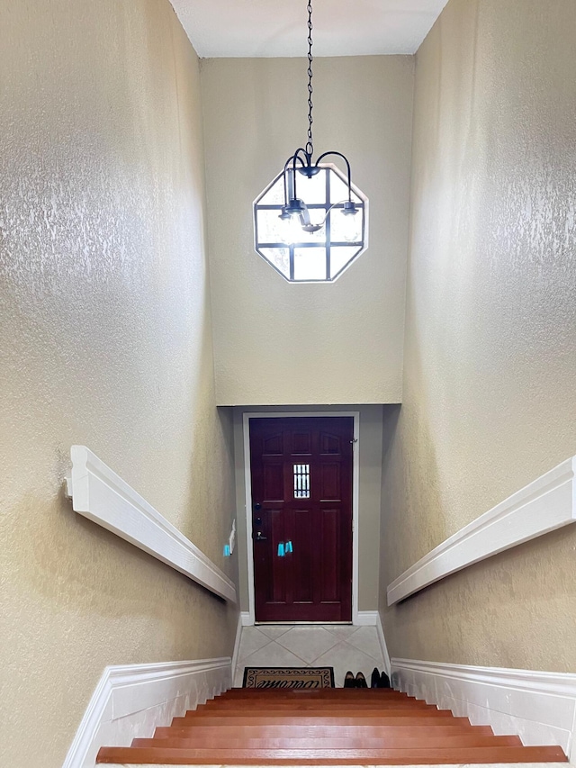 7895 La Mirada Dr, Boca Raton, FL 33433 - interior space with stairway, a textured wall, tile patterned floors, and a notable chandelier