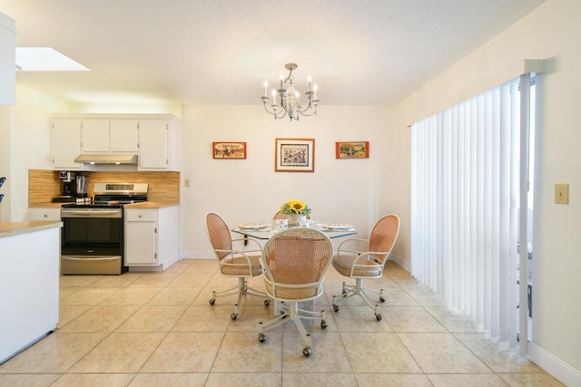 dining space with light tile patterned floors, baseboards, a chandelier, and a textured ceiling