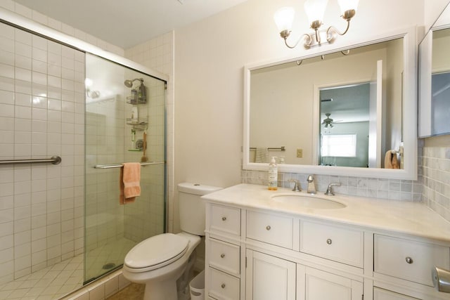 bathroom with toilet, a shower stall, and backsplash