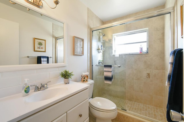 bathroom with a shower stall, toilet, and vanity