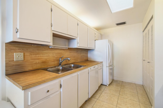 kitchen featuring visible vents, white dishwasher, light countertops, white cabinetry, and a sink