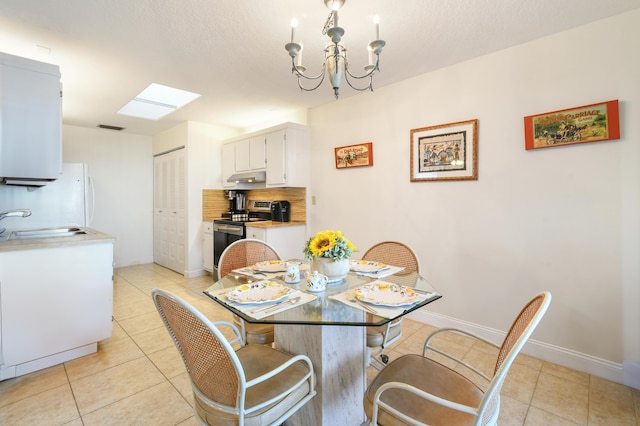 dining area featuring light tile patterned floors, visible vents, an inviting chandelier, a textured ceiling, and baseboards