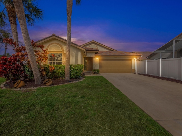 view of front of house featuring a garage and a yard