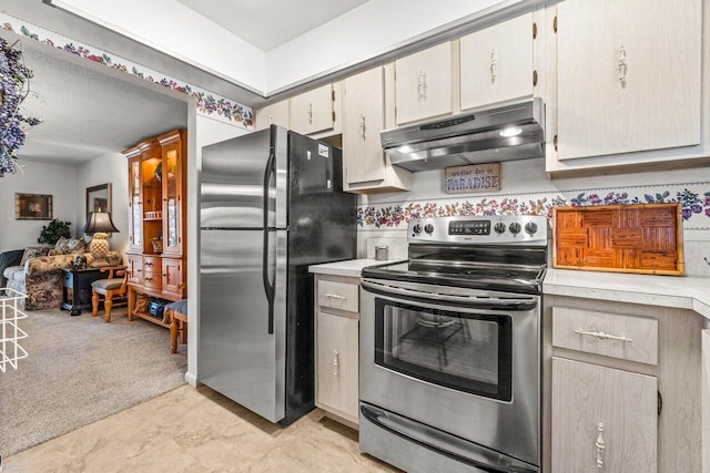 kitchen with light colored carpet and appliances with stainless steel finishes