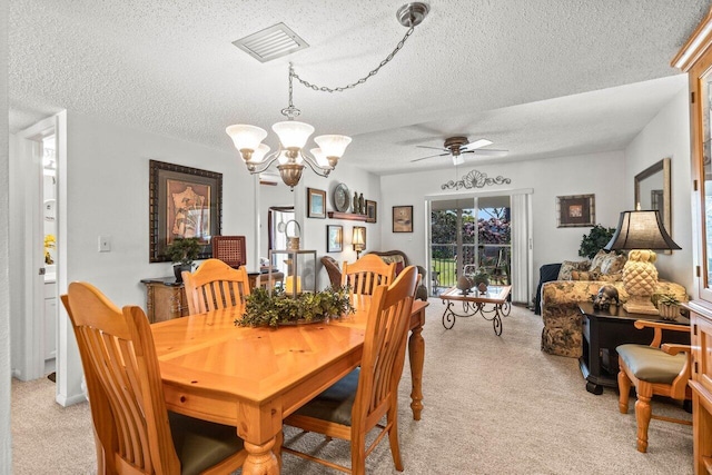 carpeted dining space featuring ceiling fan with notable chandelier and a textured ceiling