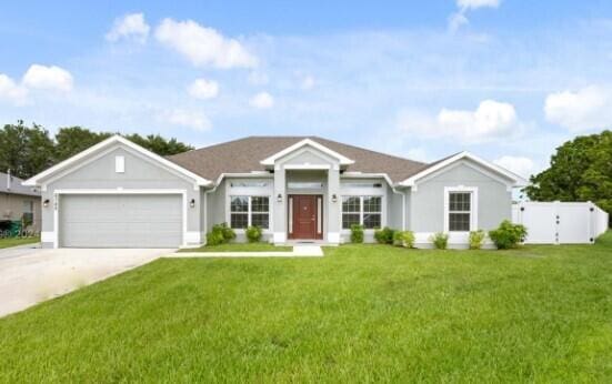 single story home featuring a garage and a front yard