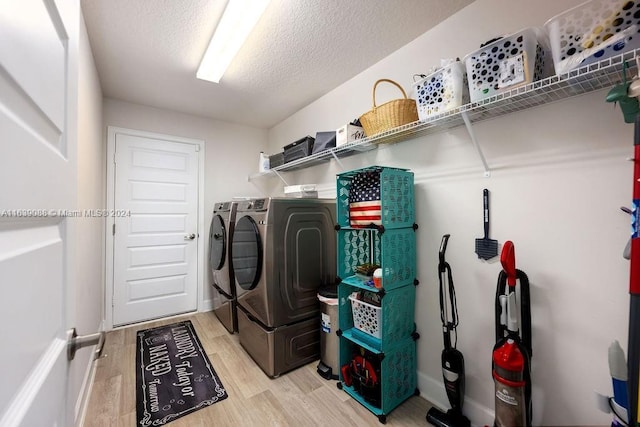 washroom with separate washer and dryer, a textured ceiling, and light hardwood / wood-style floors