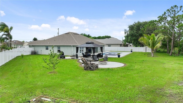 rear view of house featuring a yard, a gazebo, central air condition unit, and an outdoor fire pit