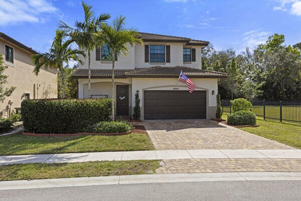 mediterranean / spanish house with a garage and a front lawn