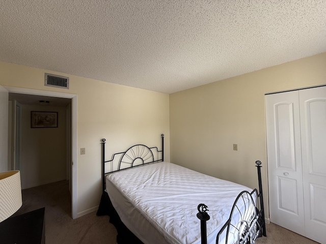 bedroom with carpet floors, a textured ceiling, and a closet