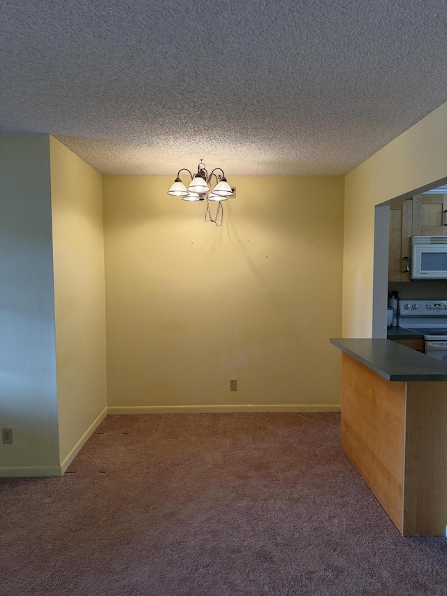 interior space featuring dark carpet, a chandelier, a textured ceiling, and white appliances