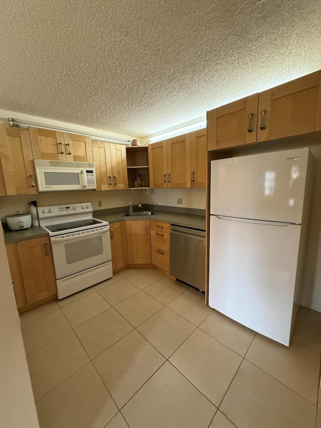 kitchen with sink, light tile patterned floors, a textured ceiling, and white appliances