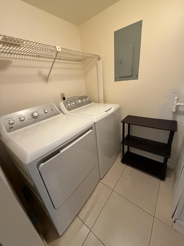 laundry area with washer and dryer, light tile patterned floors, and electric panel