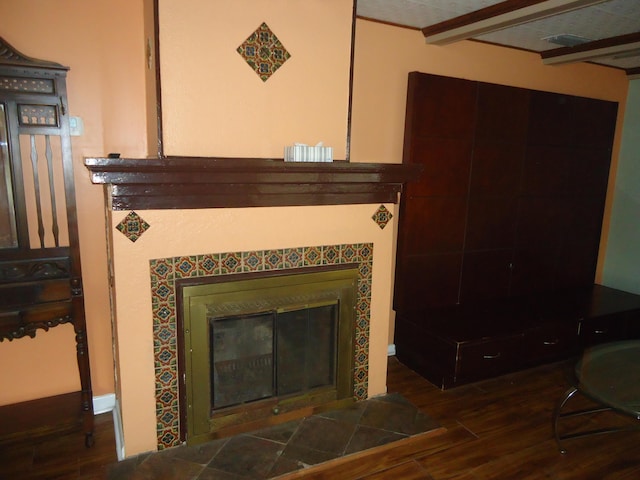 interior details with wood finished floors and a tile fireplace