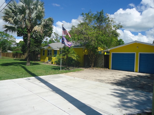 view of front of home with a garage, fence, a front lawn, and stucco siding