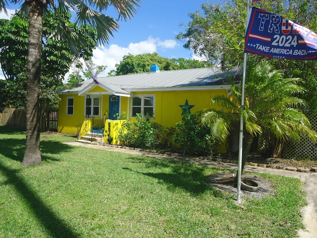 view of front of house with a front yard and metal roof