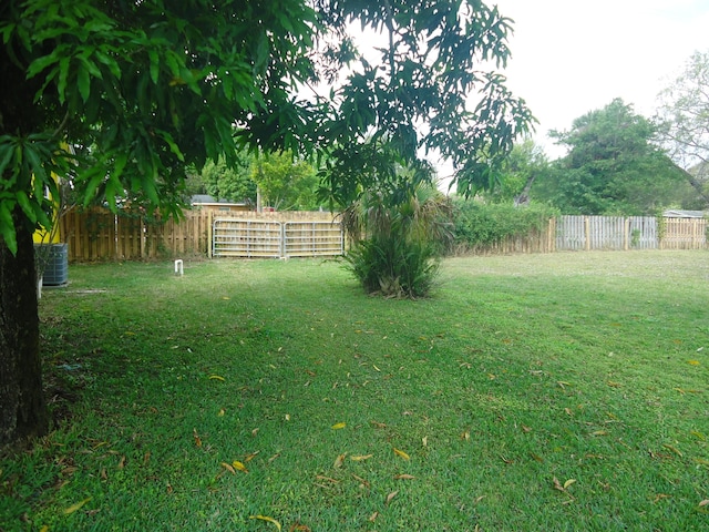 view of yard with fence and central AC