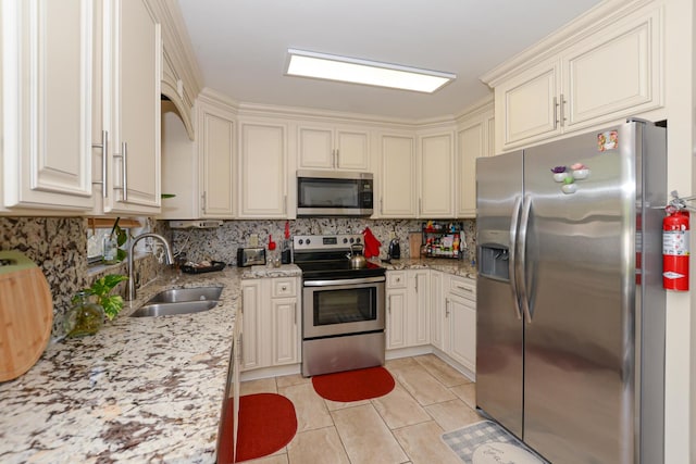 kitchen with tasteful backsplash, stainless steel appliances, sink, and light tile patterned floors