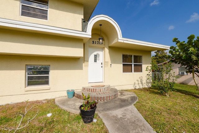 doorway to property with a lawn