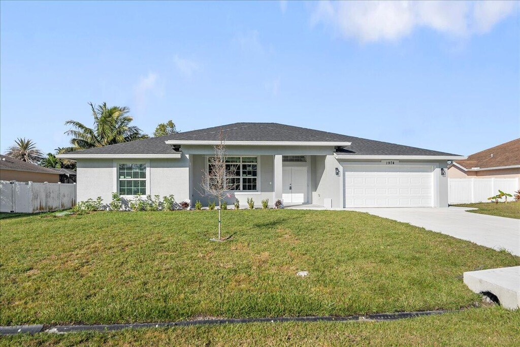 ranch-style house featuring a garage and a front yard
