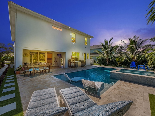 view of swimming pool with outdoor dining area, a patio, exterior kitchen, and a pool with connected hot tub