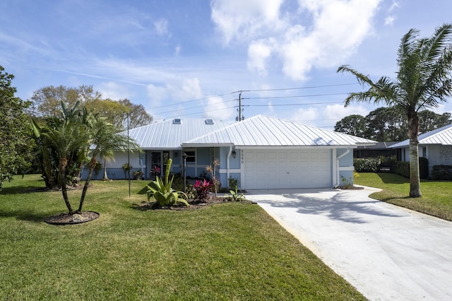 ranch-style home featuring concrete driveway, metal roof, an attached garage, a front lawn, and stucco siding