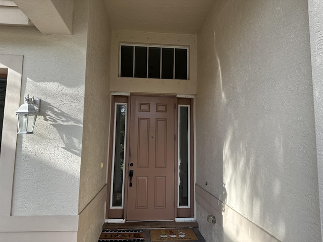 view of exterior entry with stucco siding